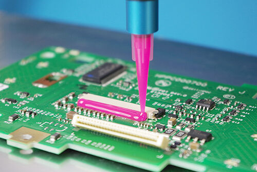 Vitralit UD 2018, ein pinker Elektronik Kleber von Panacol als Corner Bonding wir auf eine Leiterplatte PCB dosiert