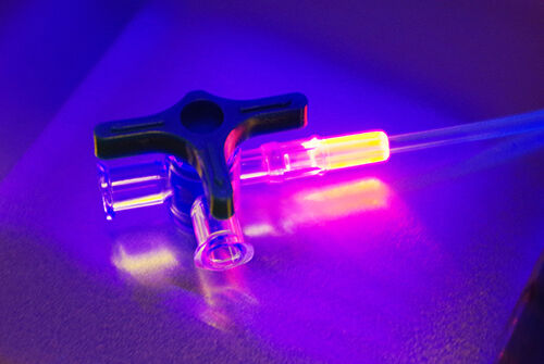 orange fluoreszierender Kleber Vitralit® 7311 FO von Panacol verbindet medizinischen Schlauch mit Ventil